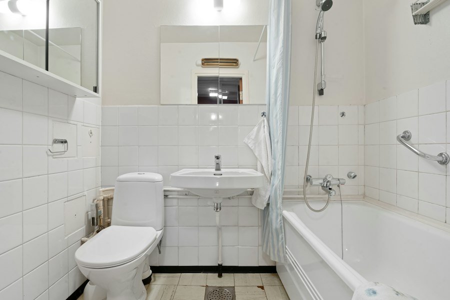 Bathroom with toilet, sink, and tub before Pine Rooter fixture installation in Bothell, WA